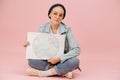 Cute female eco activist in a cap sitting cross-legged with earth banner