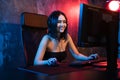 A cute female gamer girl sits in a cozy room behind a computer and plays games. Woman live streaming computer video