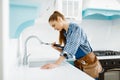 Cute female plumber in uniform fixing faucet Royalty Free Stock Photo