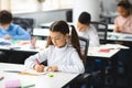 Portrait of small girl sitting at desk writing or drawing Royalty Free Stock Photo