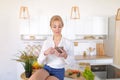 Alluring girl holds phone and reads information on Internet, sit Royalty Free Stock Photo