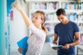 Cute female student with books in library Royalty Free Stock Photo