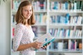 Cute female university/highschool student in library Royalty Free Stock Photo