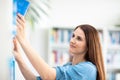 Cute female  student with books in library Royalty Free Stock Photo