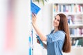 Cute female  student with books in library Royalty Free Stock Photo