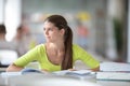 Cute female universit student with books in library Royalty Free Stock Photo
