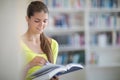 Cute female universit student with books in library Royalty Free Stock Photo