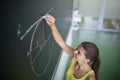 Cute female university/highschool student in class at the blackboard Royalty Free Stock Photo