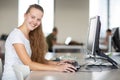 Cute female university/highschool student using a desktop computer in a library Royalty Free Stock Photo