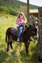 Cute fermer beautiful girl cowboy in jeans enjoying summer day in village life with flowers wearing leather cow hat happyly smilin Royalty Free Stock Photo