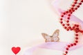 Cute festive background with red beads, hearts, ribbons and butterflies.