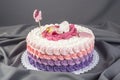 Cute festive pink cake decorated with a big flower where sleeps the little Princess. Desserts for a birthday