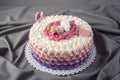 Cute festive pink cake decorated with a big flower where sleeps the little Princess. Desserts for a birthday