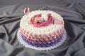 Cute festive pink cake decorated with a big flower where sleeps the little Princess. Desserts for a birthday