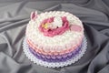 Cute festive pink cake decorated with a big flower where sleeps the little Princess. Desserts for a birthday