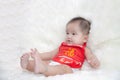 Cute five months asian baby smiling in red cheongsam.