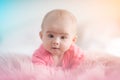 Cute five months old Baby girl infant on a bed on her belly with head up looking towards camera with her big eyes. Royalty Free Stock Photo