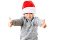 Cute five year old boy wearing a Santa Hat for Christmas with two thumbs up