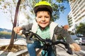 Cute five years old boy riding his bike in town