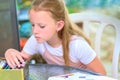 Cute freckles child drawing outdoor.