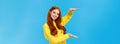 Cute friendly-looking caucasian redhead woman shaping large object with hands, presenting gift, product advertising over