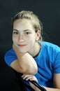 Cute teenager girl sitting on a black chair Royalty Free Stock Photo