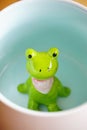 Cute frog figurine in the white mug with babyblue base Royalty Free Stock Photo