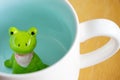 Cute frog figurine in the white mug with babyblue base Royalty Free Stock Photo