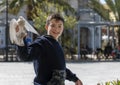 Cute and full of joy boy , is playing in the square , while feeding the pigeons he finally managed to catch one . Enthusiasm is