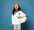 Cute and funny asian kid girl with lollipop in her hand posing with polar bear toy and laugh Royalty Free Stock Photo