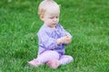 Cute funny baby girl sitting on grass on a meadow Royalty Free Stock Photo