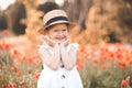 Cute funny baby girl 2-3 year old wear straw hat and white summer dress over flower meadow background. Kid laughing outdoors over Royalty Free Stock Photo