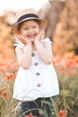 Cute funny baby girl 2-3 year old wear straw hat and white summer dress over flower meadow background. Kid laughing outdoors over Royalty Free Stock Photo