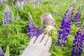 Cute and funny baby in plants. Large and beautiful lupine flowers. Portrait of child. Royalty Free Stock Photo