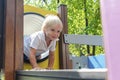 Cute funny blond little young toddler kid child boy crawling climbing through yellow plastic tunnel,pipe in playground.Children Royalty Free Stock Photo