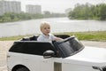 Cute funny blond little young toddler kid child boy sitting,driving,riding in electric toy car,automobile,jeep in park.Children Royalty Free Stock Photo