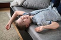 Cute funny boy lying upside down on sofa looking at camera, smiling playful child boy having fun at home Royalty Free Stock Photo