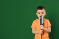 Cute funny boy with microphone on color background. Royalty Free Stock Photo