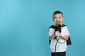 Cute funny boy with microphone on color background. Royalty Free Stock Photo