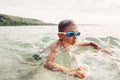 Cute funny Caucasian boy swimming in lake river with underwater goggles. Royalty Free Stock Photo