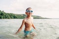 Cute funny Caucasian boy swimming in lake river with underwater goggles. Child diving in water Royalty Free Stock Photo