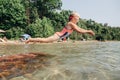 Cute funny Caucasian girl diving in lake with underwater goggles. Child swimming in water on the Awenda beach. Authentic real Royalty Free Stock Photo