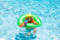 Cute funny child boy relaxing with toy swimming ring in a swim pool having fun during summer vacation in a tropical Royalty Free Stock Photo