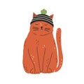 Cute and funny ginger cat wearing knitted hat with pompom and sitting with closed eyes. Adorable kitty meditating. Hand Royalty Free Stock Photo