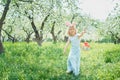 Cute funny girl with Easter eggs and bunny ears at garden. easter concept. Laughing child at Easter egg hunt