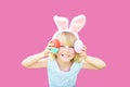 Cute funny girl with Easter eggs and bunny ears at garden. easter concept. Laughing child at Easter egg hunt