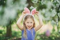 Cute funny girl with Easter eggs and bunny ears at garden. easter concept. Laughing child at Easter egg hunt