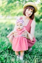 Cute funny happy baby making his first steps on a green grass, mother holding her hands supporting by learning to walk Royalty Free Stock Photo