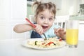 Cute funny kid eating noodles.Little girl have a meal.Happy preschooler lifestyle portrait