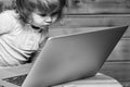 Cute funny little baby boy playing on computer and mobile phone near toy building blocks indoors. Royalty Free Stock Photo